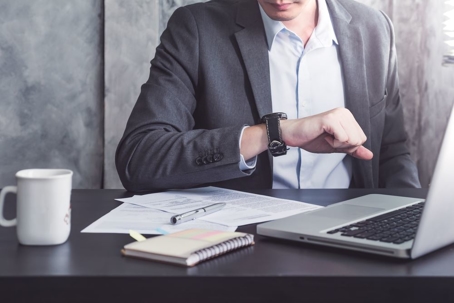 Man looking at his watch at office desk